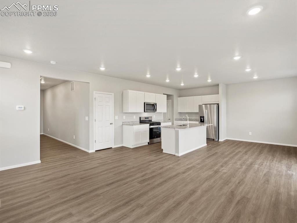 6754 Roundtail Way Colorado Springs, CO 80925 - Photo 3 of 31 a view of kitchen with wooden floor and electronic appliances