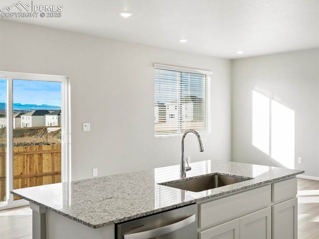 6754 Roundtail Way Colorado Springs, CO 80925 - Photo 7 of 31 a kitchen with granite countertop a sink and potted plant