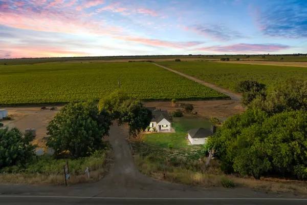 an aerial view of a house with a garden and lake view