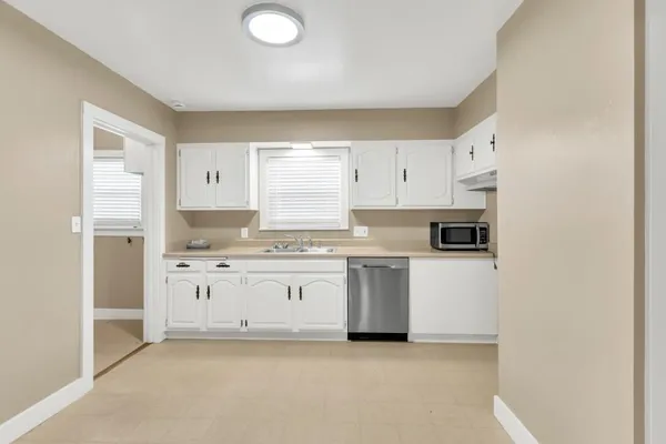 a kitchen with granite countertop a sink stove and refrigerator