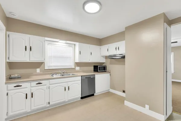a kitchen with white cabinets and white appliances