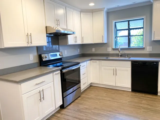 a kitchen with granite countertop stainless steel appliances a refrigerator sink and cabinets