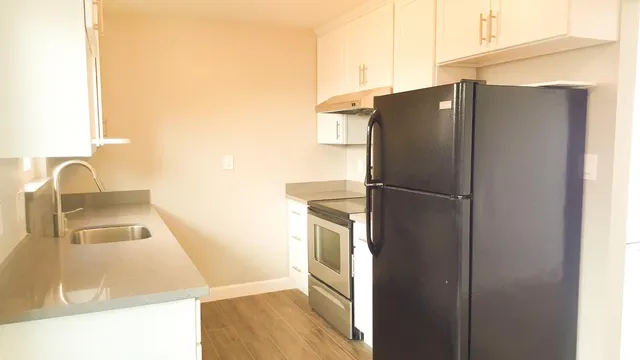 a kitchen with granite countertop white cabinets and a sink