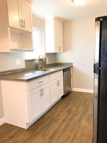 a kitchen with granite countertop a sink and a stove top oven