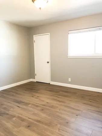 a bathroom with a glass shower door and a wooden floor
