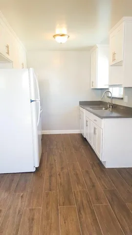 a kitchen with a sink cabinets and wooden floor