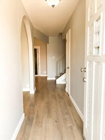 an empty room with wooden floor fireplace and windows