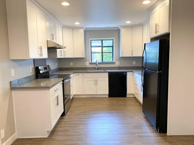 a kitchen with stainless steel appliances white cabinets and a sink