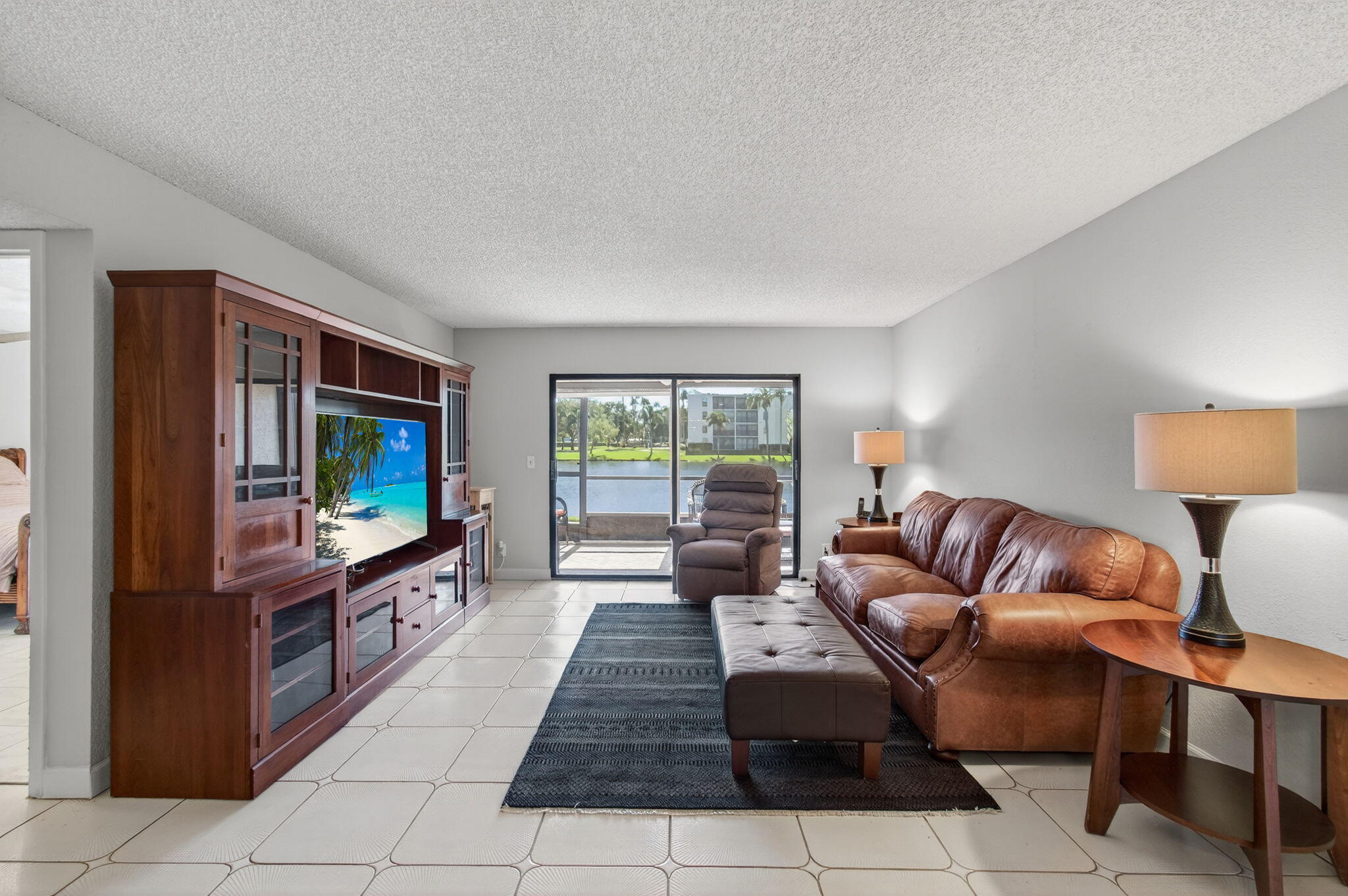 7340 Amberly Lane, Unit 101 Delray Beach, FL 33446 - Photo 15 of 90 a living room with furniture and a flat screen tv