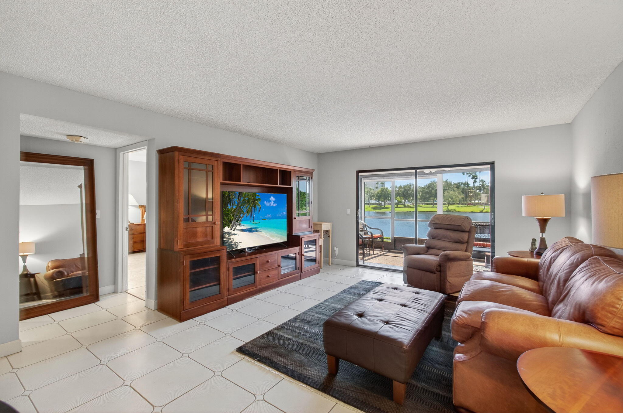 7340 Amberly Lane, Unit 101 Delray Beach, FL 33446 - Photo 16 of 90 a living room with furniture and a flat screen tv