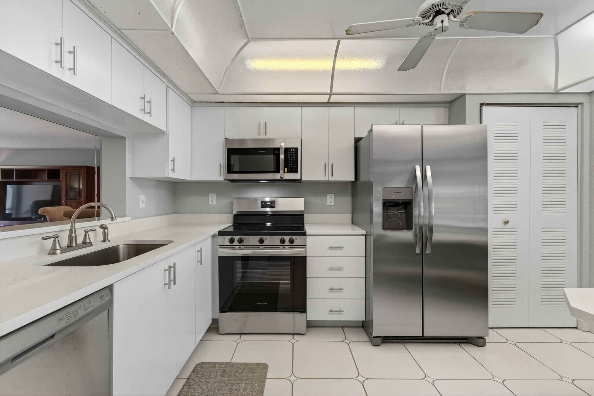 7340 Amberly Lane, Unit 101 Delray Beach, FL 33446 - Photo 26 of 90 a kitchen with stainless steel appliances granite countertop a refrigerator a stove a sink and a microwave