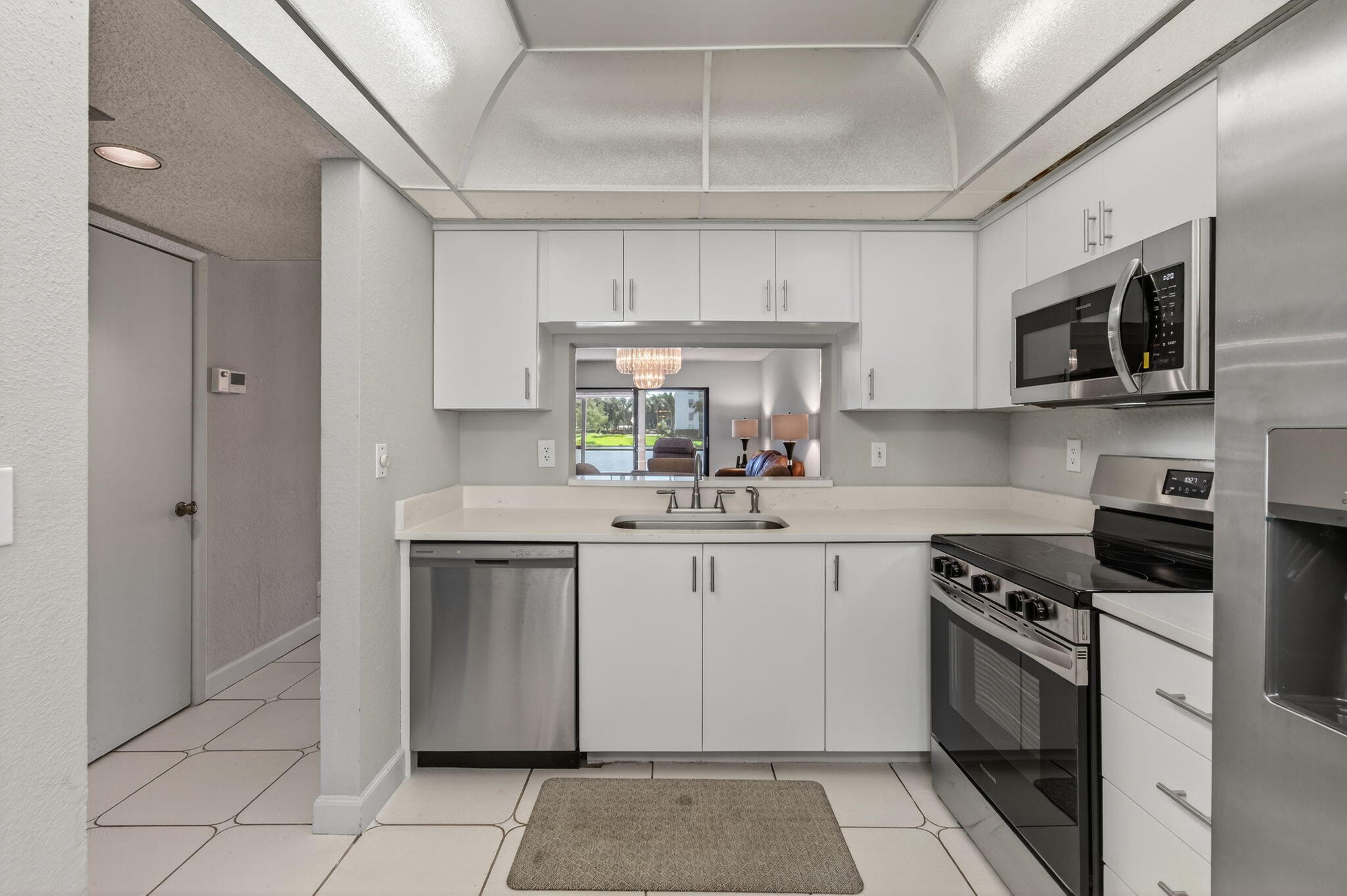 7340 Amberly Lane, Unit 101 Delray Beach, FL 33446 - Photo 30 of 90 a kitchen with stainless steel appliances granite countertop a stove top oven a sink dishwasher and a refrigerator with wooden cabinets