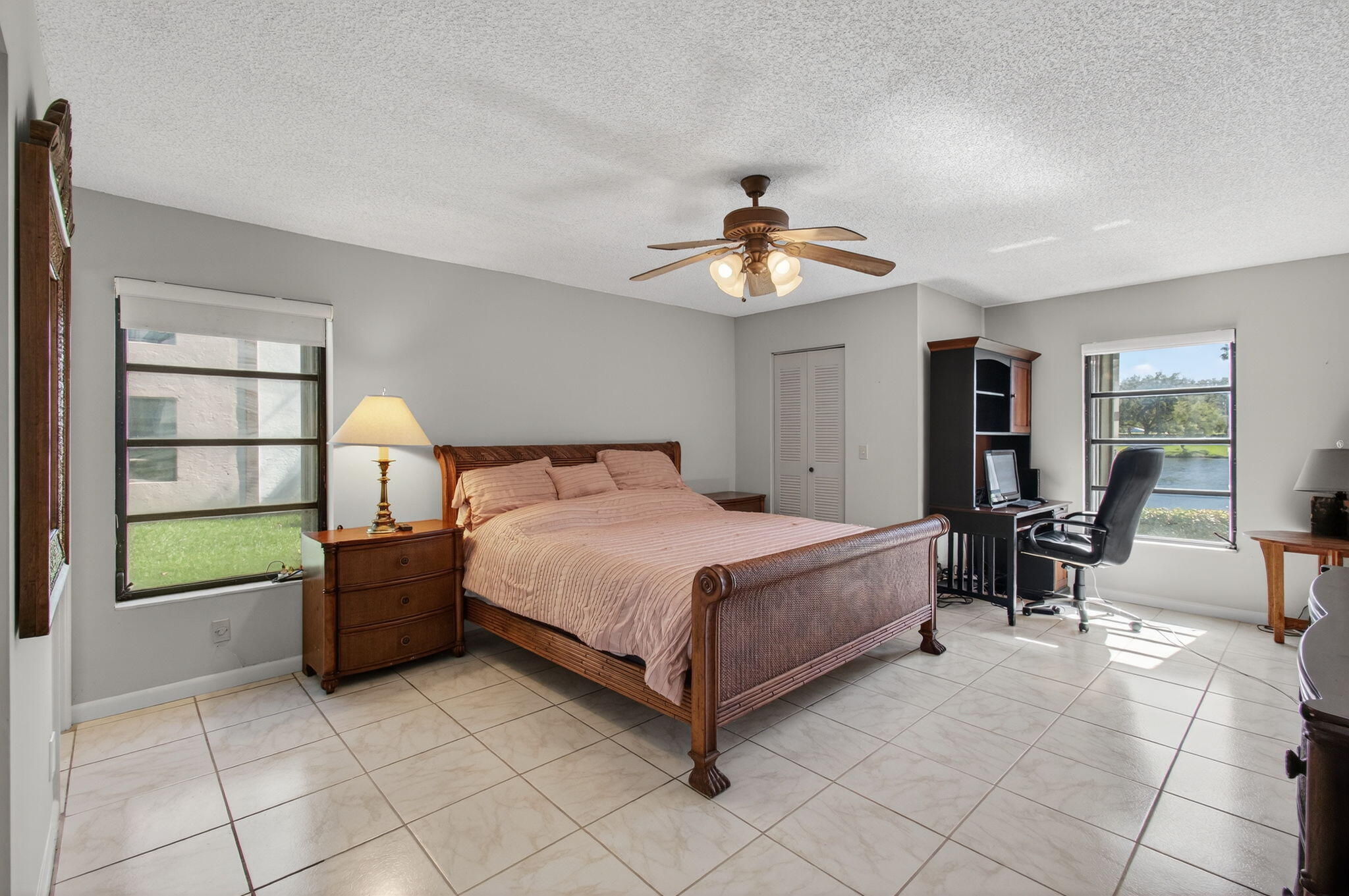 7340 Amberly Lane, Unit 101 Delray Beach, FL 33446 - Photo 31 of 90 a spacious bedroom with a bed and a chandelier