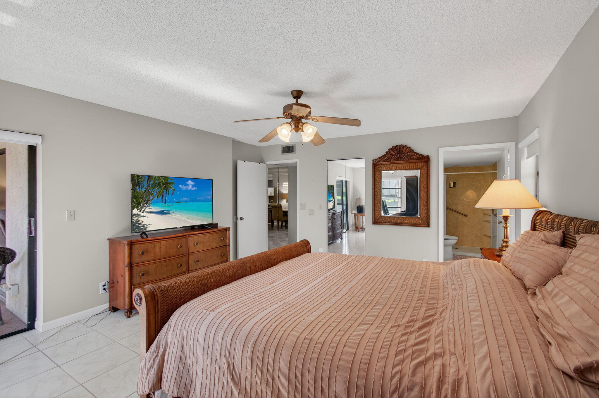 7340 Amberly Lane, Unit 101 Delray Beach, FL 33446 - Photo 36 of 90 a bedroom with a large bed and a chandelier
