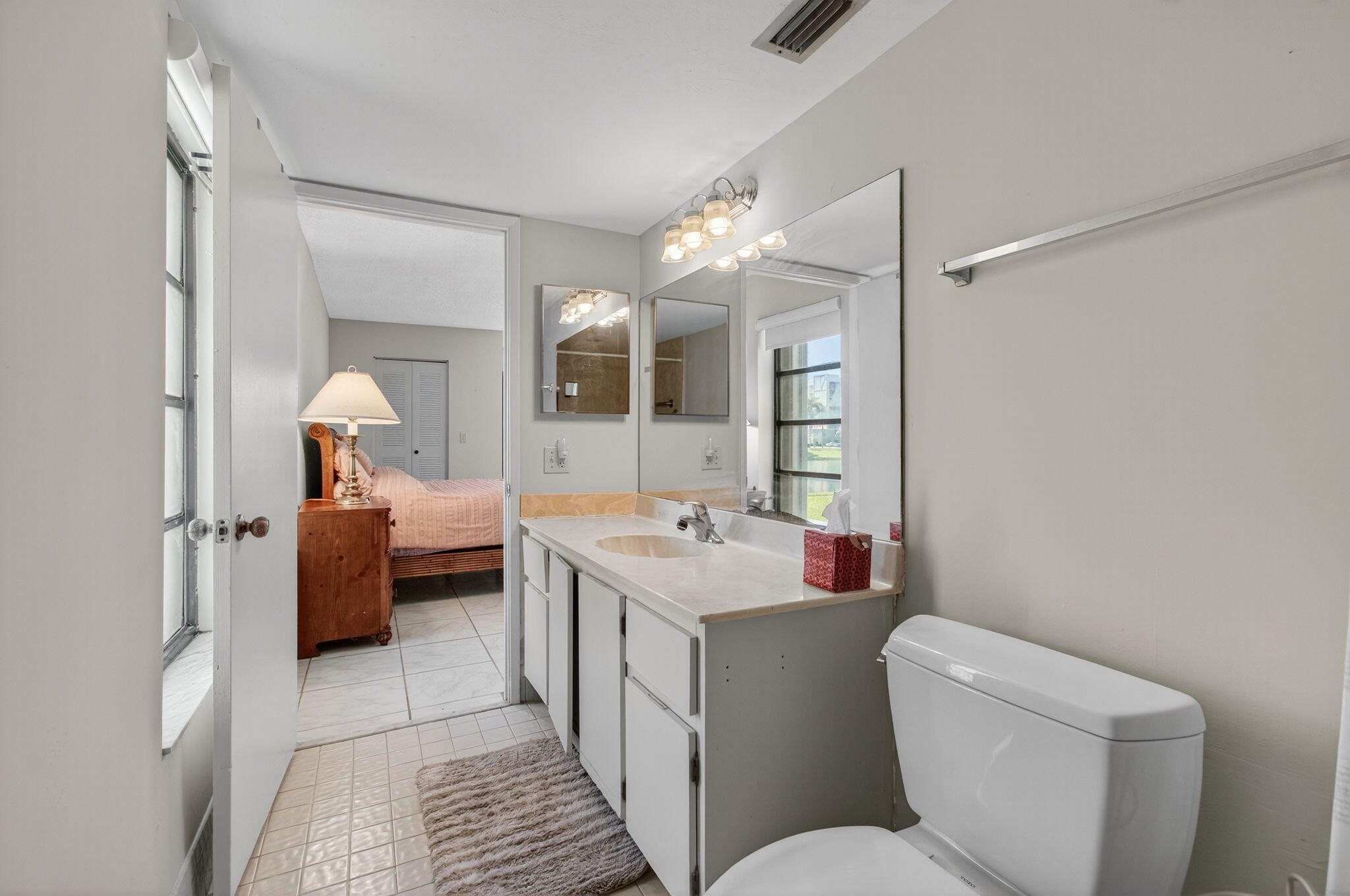 7340 Amberly Lane, Unit 101 Delray Beach, FL 33446 - Photo 43 of 90 a bathroom with a toilet sink and mirror