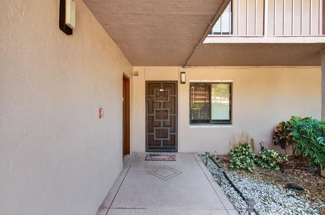 a living room with furniture two large window and a rug