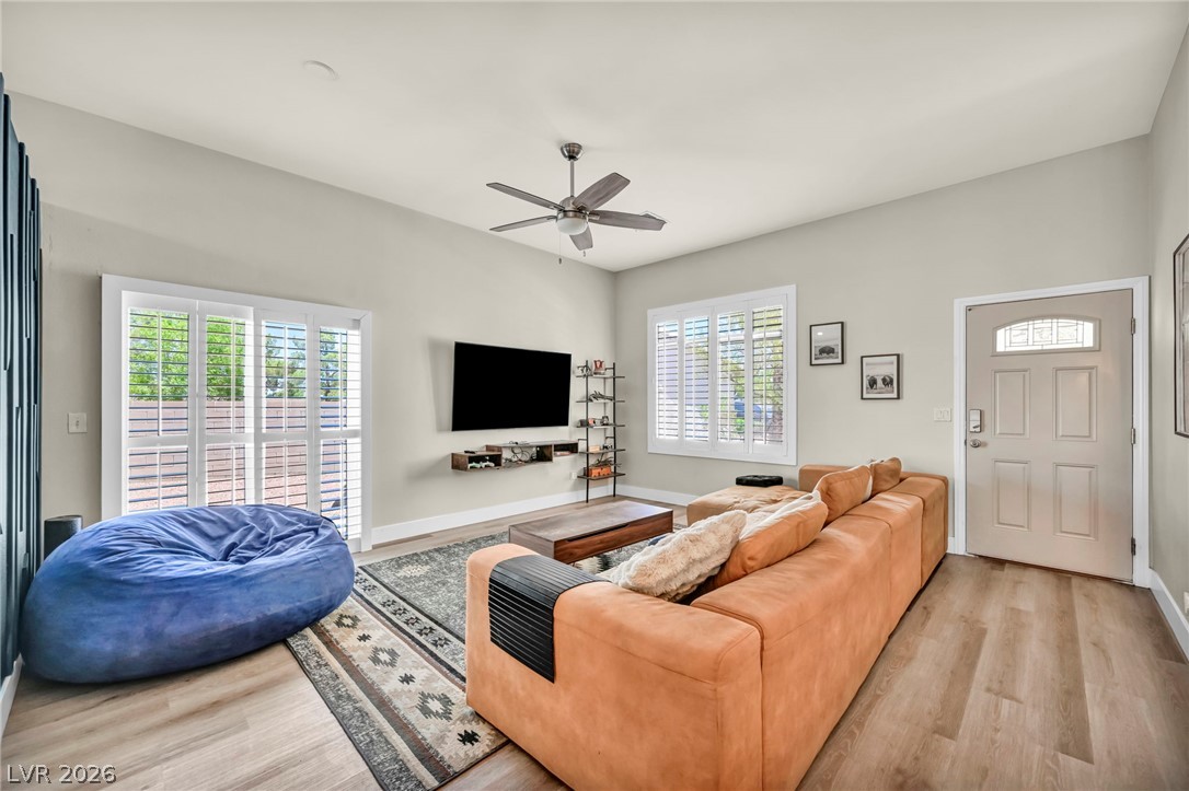 1234 Sunfire Street Henderson, NV 89014 - Photo 5 of 40 A well-lit living area showcases rich hardwood flooring and a stylish ceiling fan.