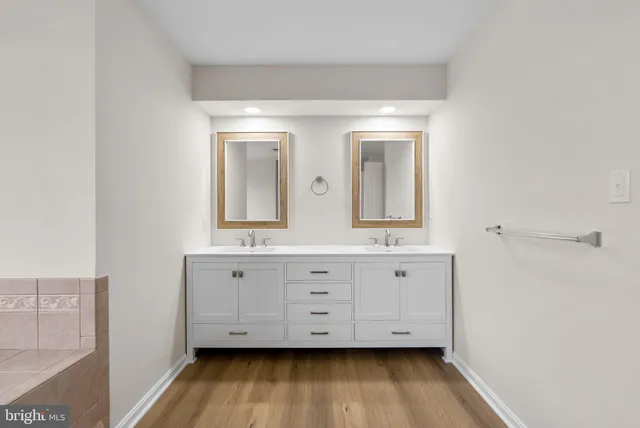 a bathroom with double vanity sink and mirror