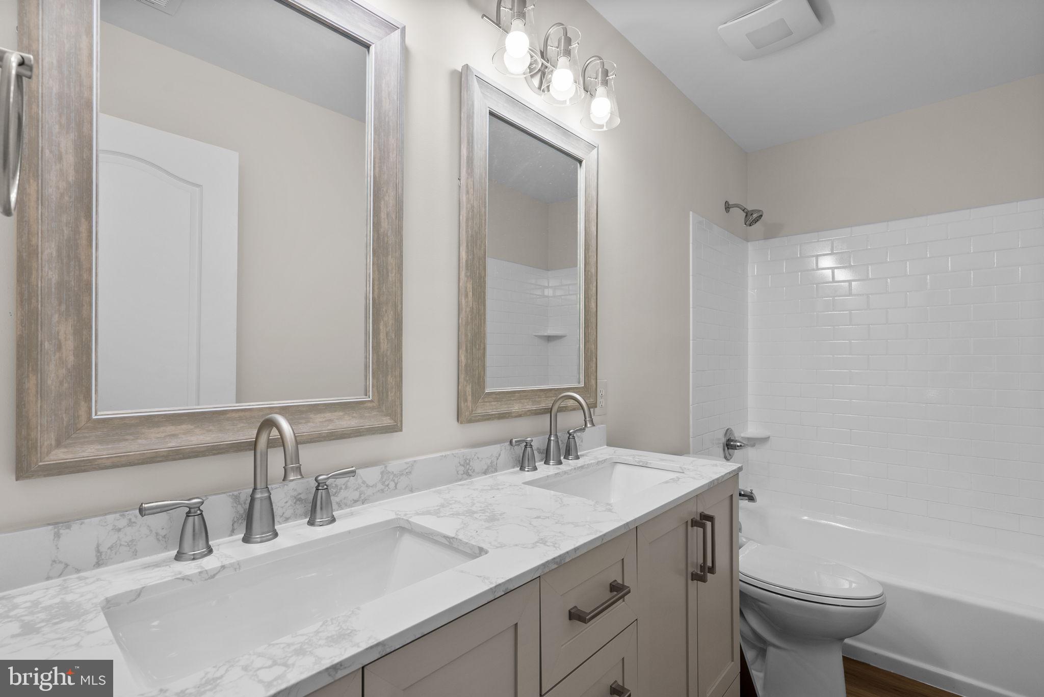 7604 Finglas Court Laurel, MD 20707 - Photo 41 of 48 a bathroom with a granite countertop sink a toilet and a mirror
