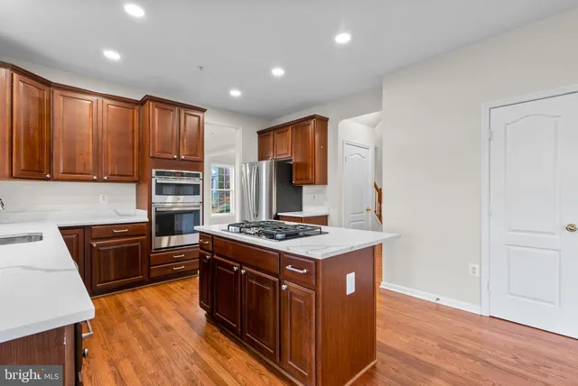 a kitchen with stainless steel appliances granite countertop a stove a sink dishwasher and a refrigerator