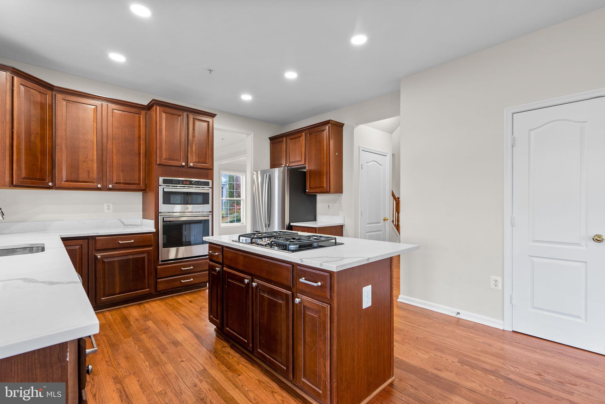 7604 Finglas Court Laurel, MD 20707 - Photo 7 of 48 a kitchen with stainless steel appliances granite countertop a stove a sink dishwasher and a refrigerator