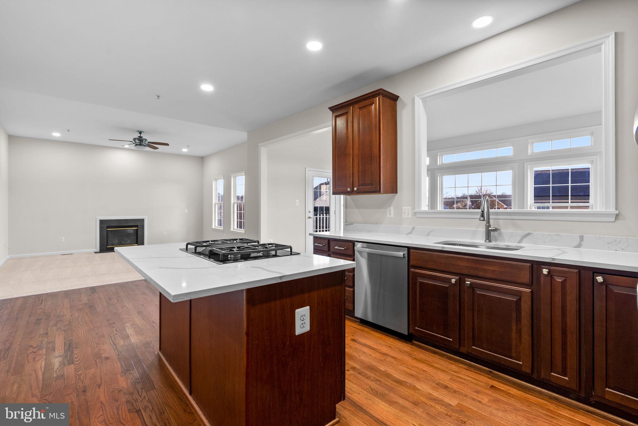 7604 Finglas Court Laurel, MD 20707 - Photo 8 of 48 a kitchen with a sink a stove cabinets and wooden floor