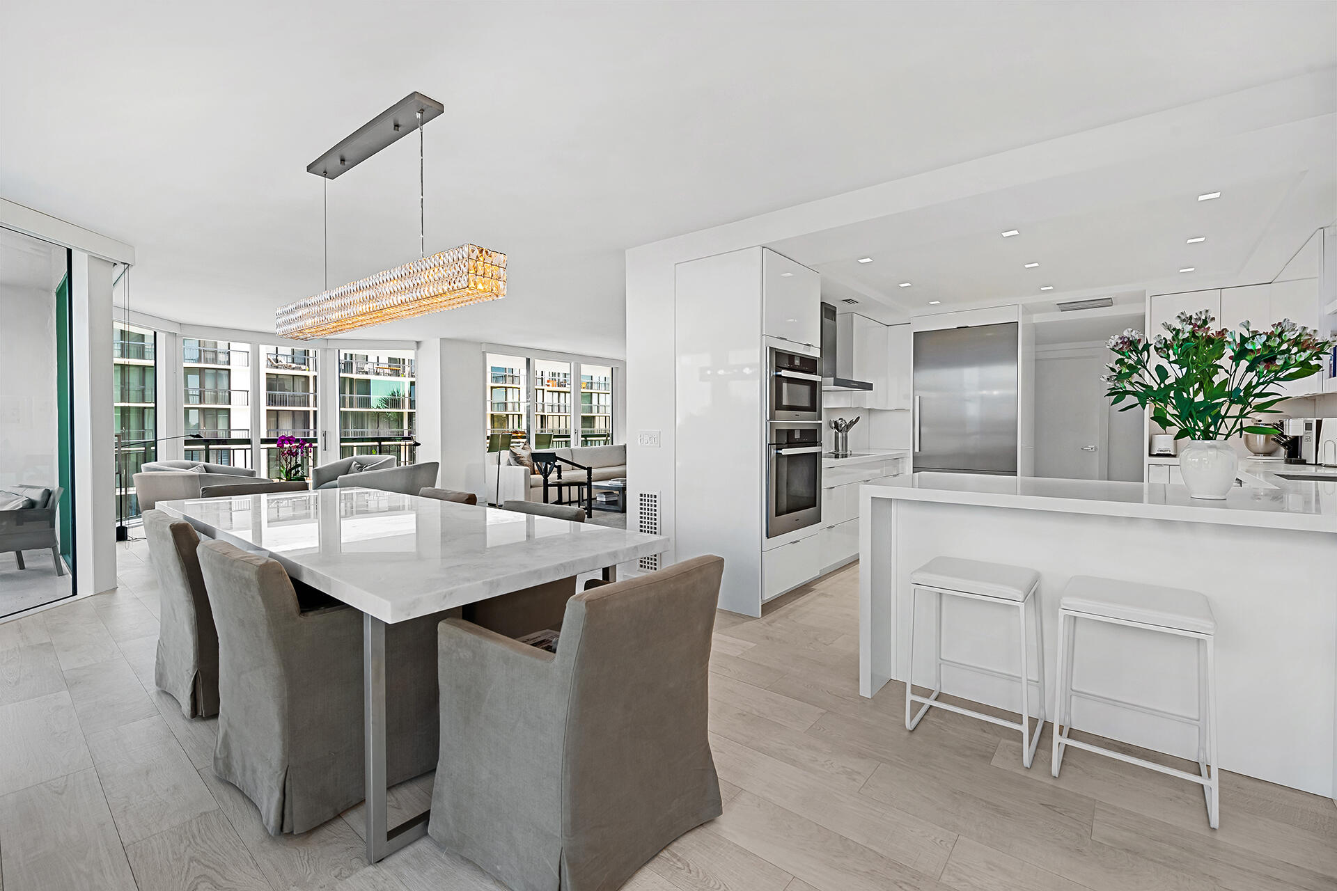 3140 South Ocean Boulevard, Unit 307S Palm Beach, FL 33480 - Photo 11 of 58 a kitchen with stainless steel appliances kitchen island a table chairs in it and white cabinets
