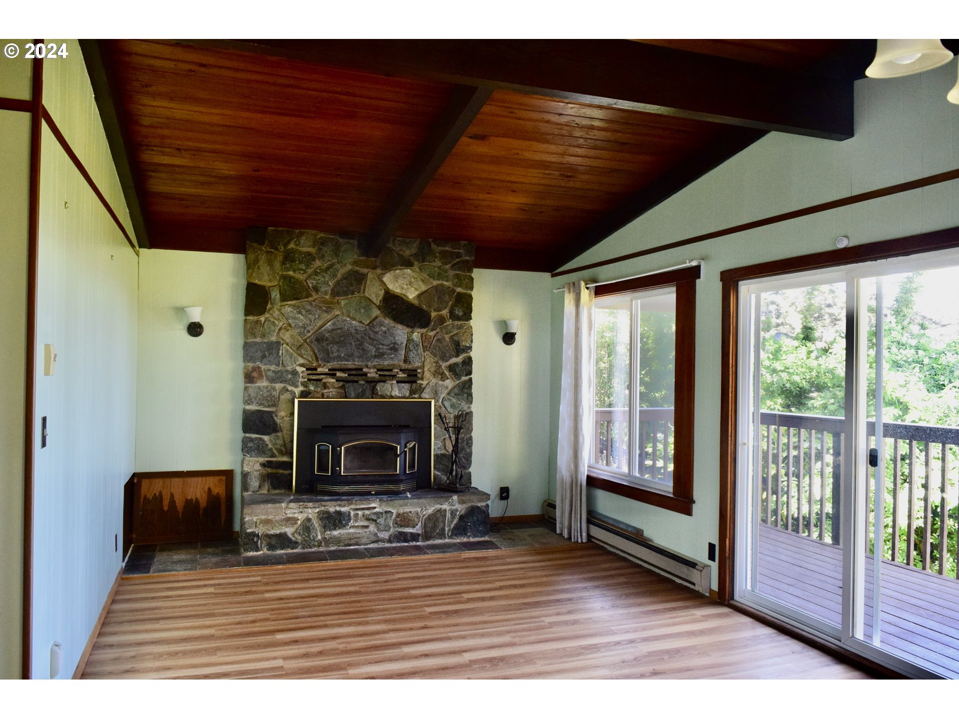 29280 Lacy Street Gold Beach, OR 97444 - Photo 16 of 38 a living room with furniture a fireplace and a wooden floor