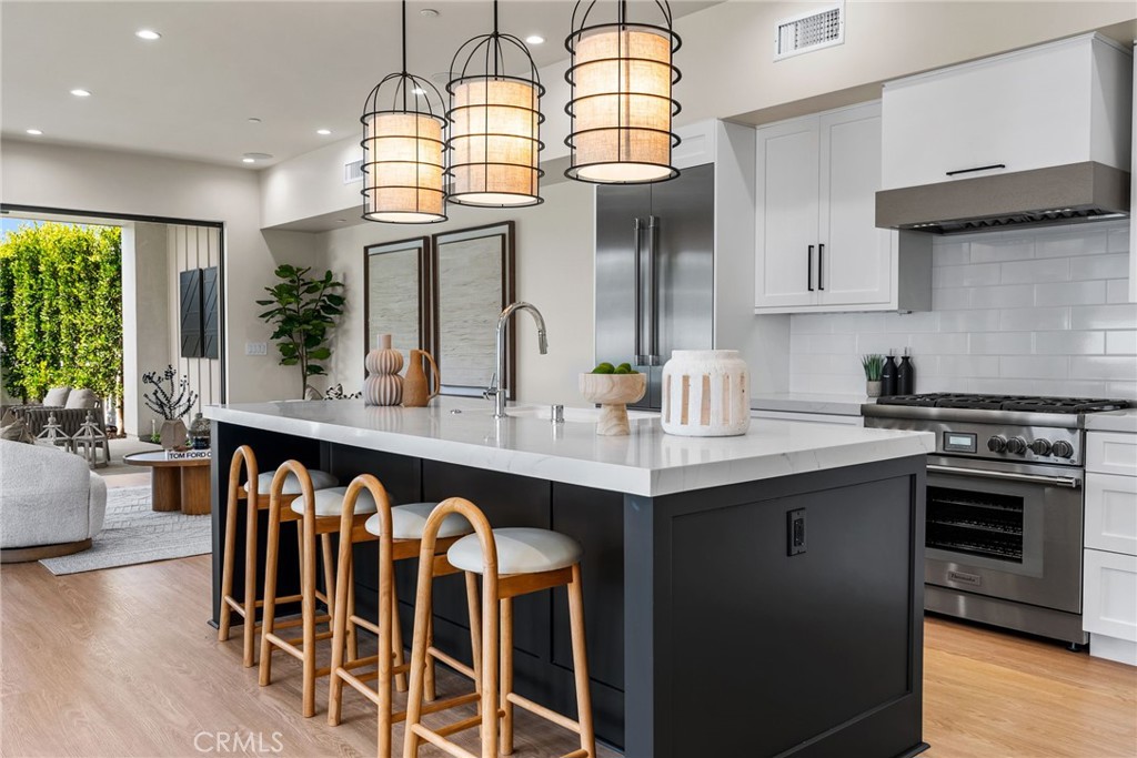 161 Cecil Place, Unit A Costa Mesa, CA 92627 - Photo 13 of 63 a kitchen with a dining table chairs sink and stove
