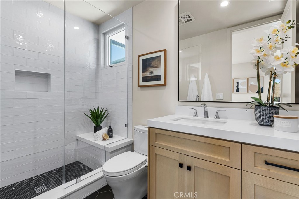 161 Cecil Place, Unit A Costa Mesa, CA 92627 - Photo 46 of 63 a bathroom with a granite countertop sink a toilet and a mirror