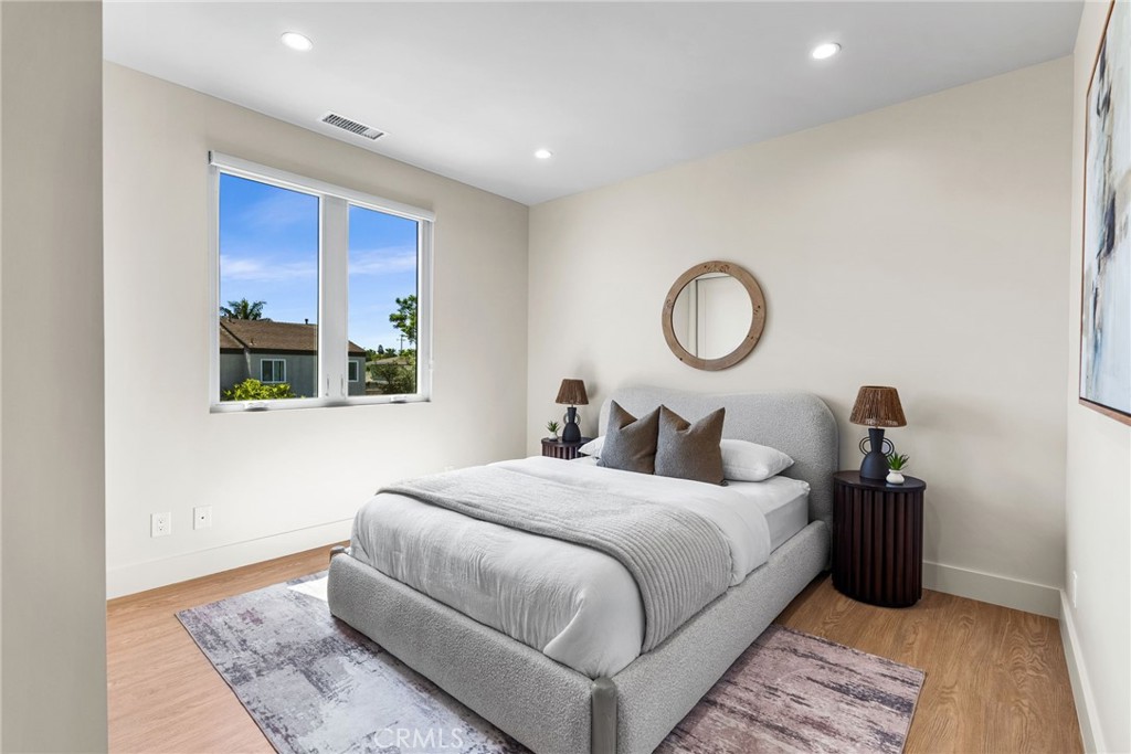 161 Cecil Place, Unit A Costa Mesa, CA 92627 - Photo 48 of 63 a bedroom with a bed and lamp
