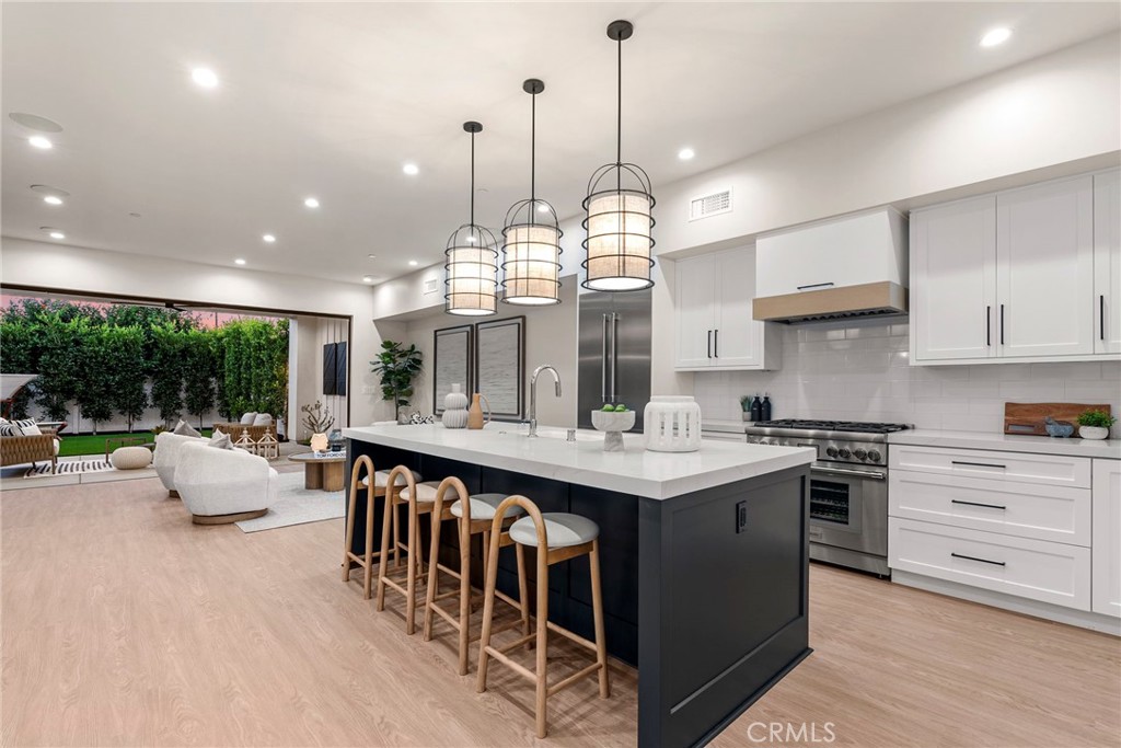 161 Cecil Place, Unit A Costa Mesa, CA 92627 - Photo 9 of 63 a open kitchen with stainless steel appliances granite countertop a stove a sink dishwasher a couches and chairs with wooden floor