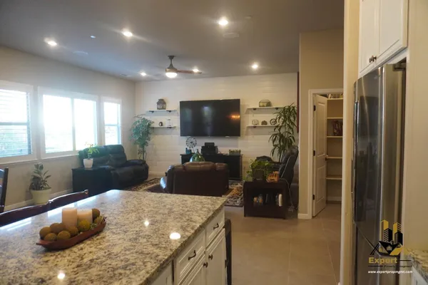a living room with stainless steel appliances kitchen island granite countertop furniture and a dining table