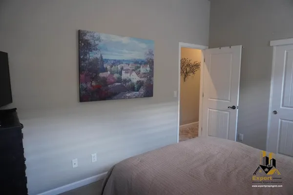 a bedroom with a bed and a lamp on dresser