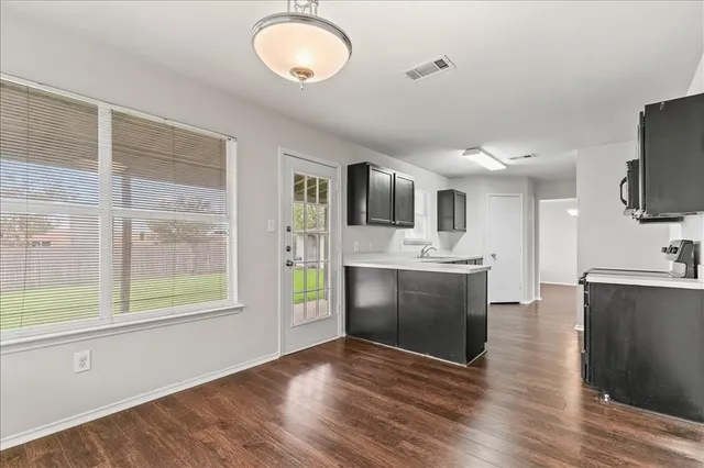 a view of a kitchen with a sink a stove top oven and cabinets