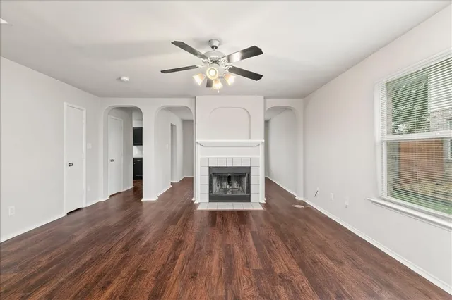 a view of an empty room with a fireplace and a window