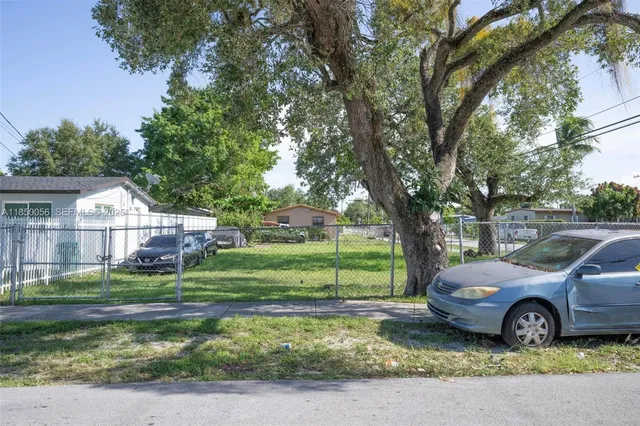 a view of a house with a big yard and large trees