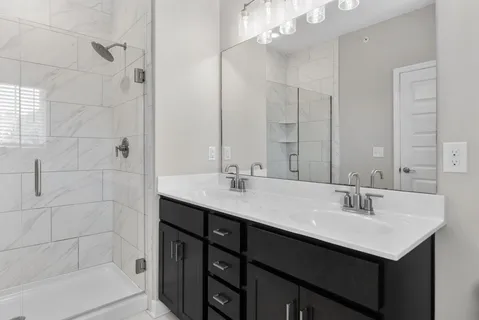a bathroom with a sink double vanity and shower