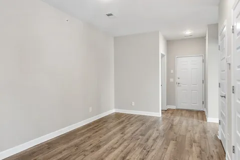 a view of an empty room with wooden floor