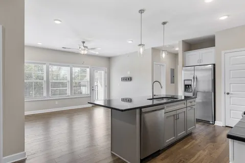 a kitchen with stainless steel appliances granite countertop a sink a stove and a refrigerator
