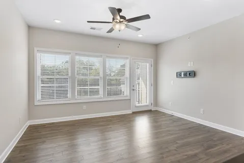 a view of wooden floor and a chandelier fan in a room
