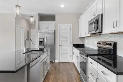 a kitchen with stainless steel appliances granite countertop a refrigerator stove and sink