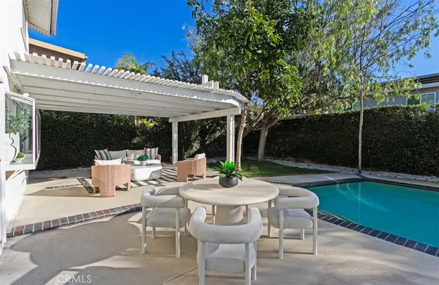 a view of a patio with couches chairs and a table and chairs with the garden view