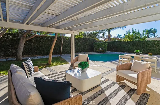 a view of a patio with couches chairs and a table and a floor to ceiling window