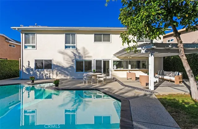 a view of a house with pool and chairs