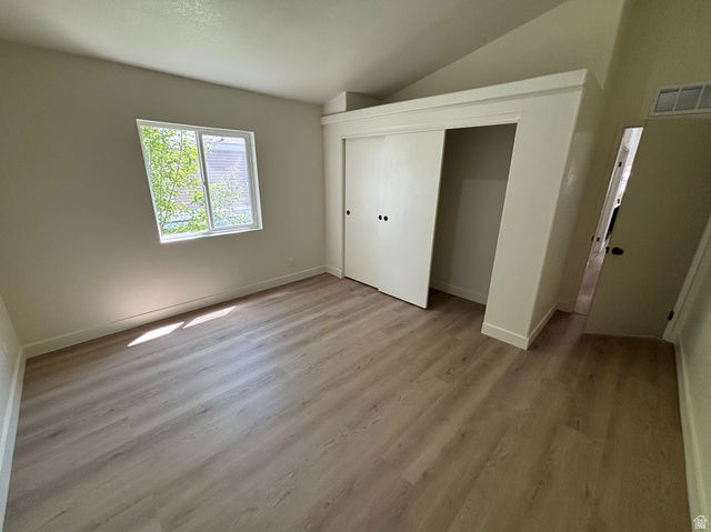 11313 South 265 East Sandy, UT 84070 - Photo 12 of 21 Room featuring wood-finish flooring, a bright window, and a built-in closet with sliding doors