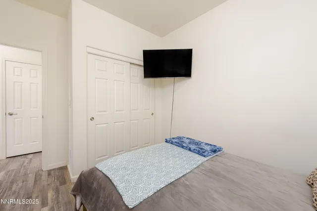a bedroom with a bed and a flat screen tv