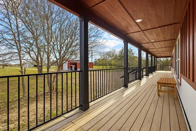 a view of balcony with wooden floor and floor to ceiling window