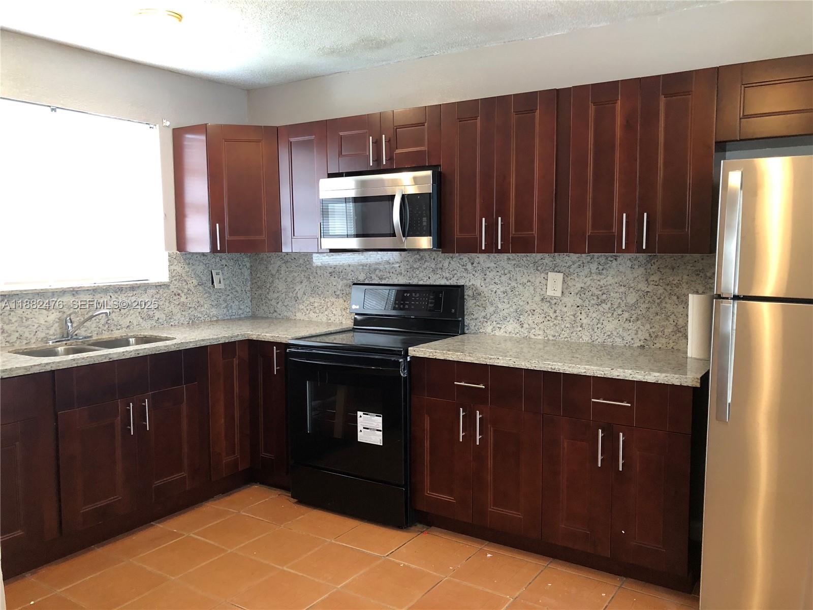 10250 Southwest 172nd Street Miami, FL 33157 - Photo 2 of 39 a kitchen with stainless steel appliances granite countertop a refrigerator a stove a sink and dishwasher