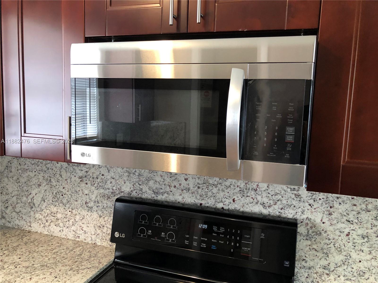 10250 Southwest 172nd Street Miami, FL 33157 - Photo 22 of 39 a kitchen with granite countertop a stove and a microwave